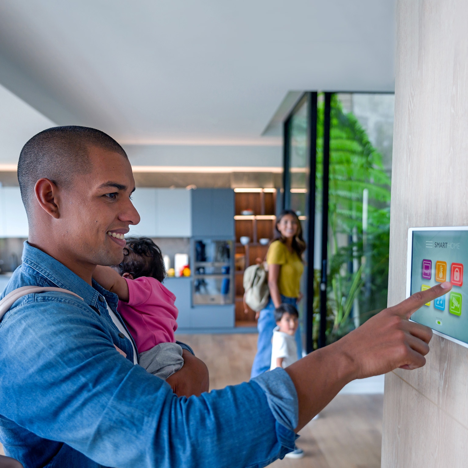 Happy Latin American family leaving a luxury apartment locking the door using a home automation system