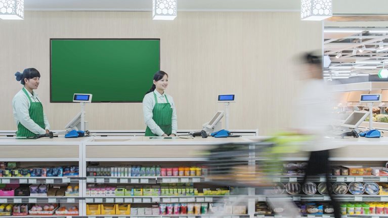 Supermarket staff standing at check-out counter