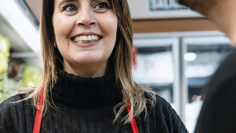Female manager talking to employee holding a tablet preparing an online order at the refrigerated section