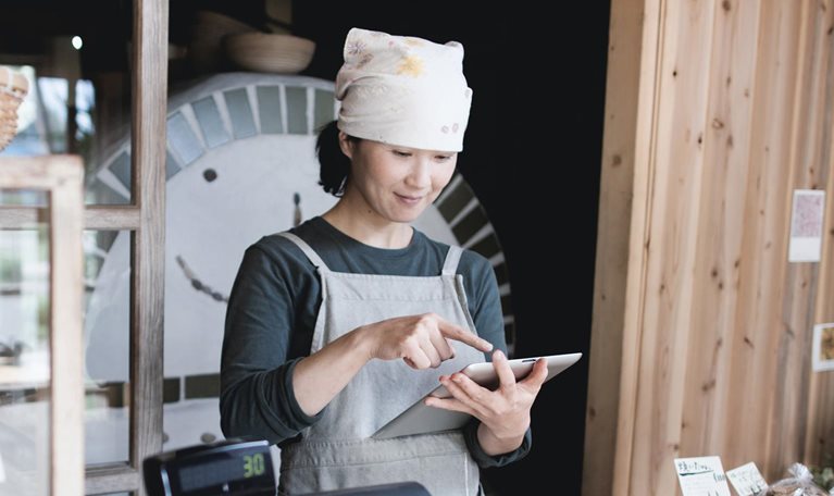 Woman using tablet computer in a small bakery