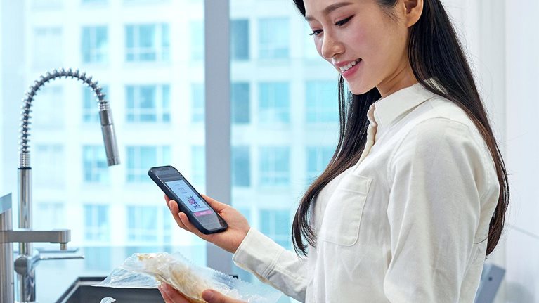 Smiling Woman with Meal Kit - stock photo
