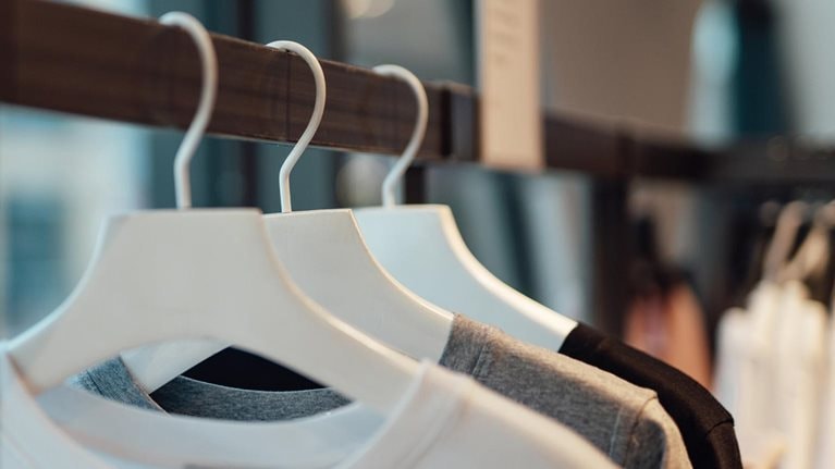 Clothes hanging on rack in fashion store