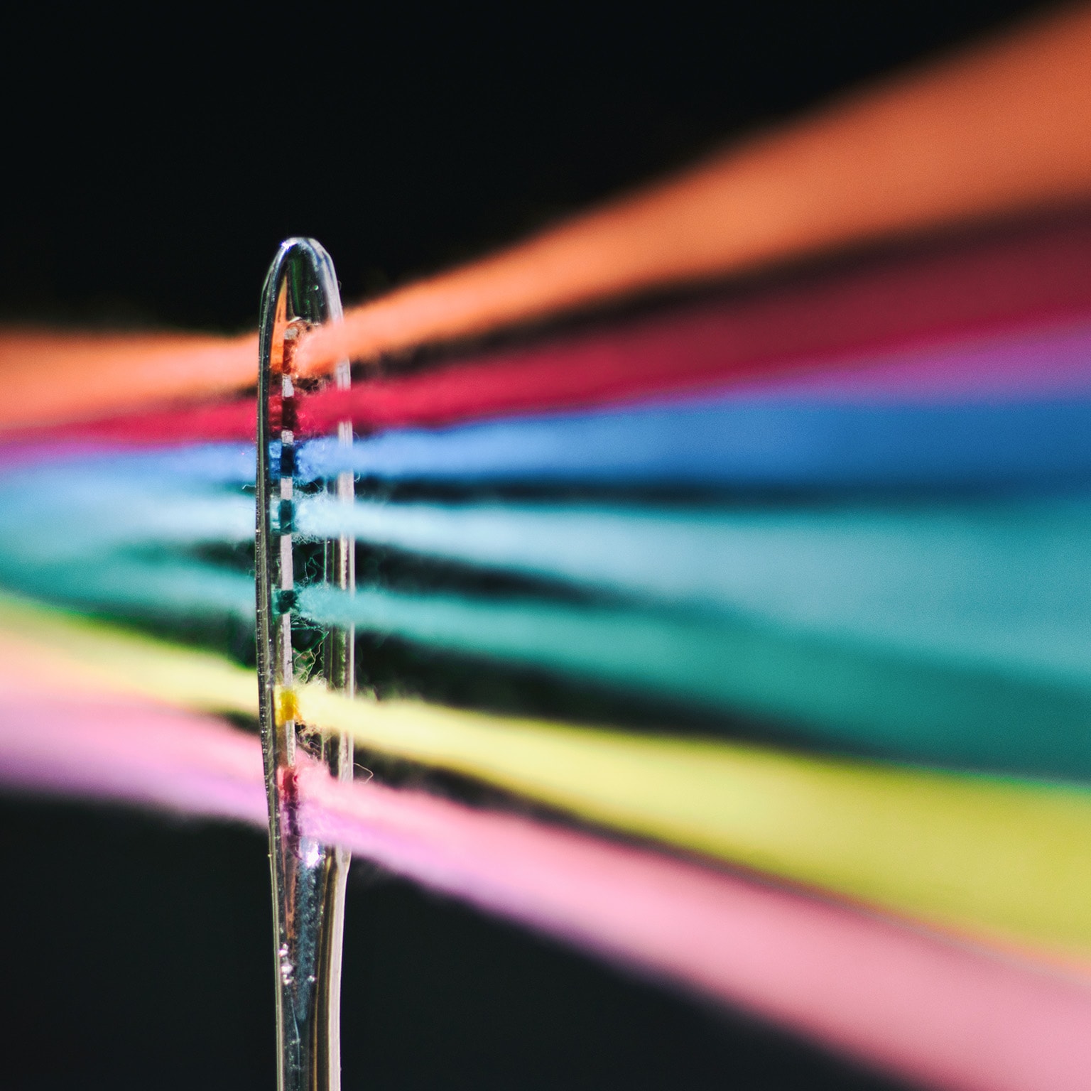 Needle of sewing and its colored threads - stock photo