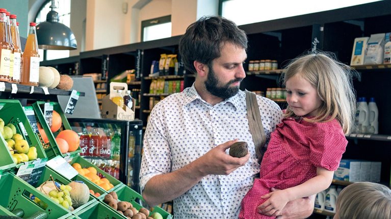 A father with his children in a retail store isle holding a displayed item