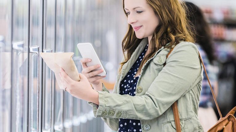 Woman using phone at grocery store