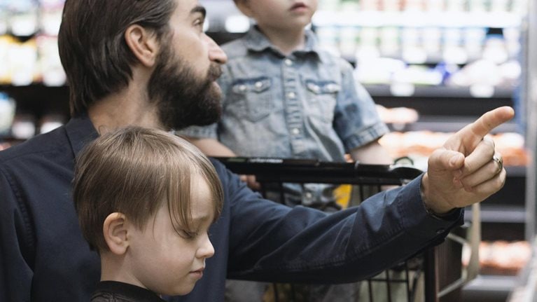 Father grocery shopping with his two children