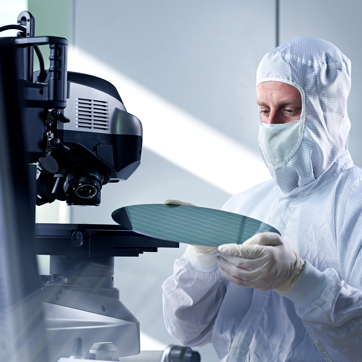 Engineer putting wafer chip on microscope in laboratory