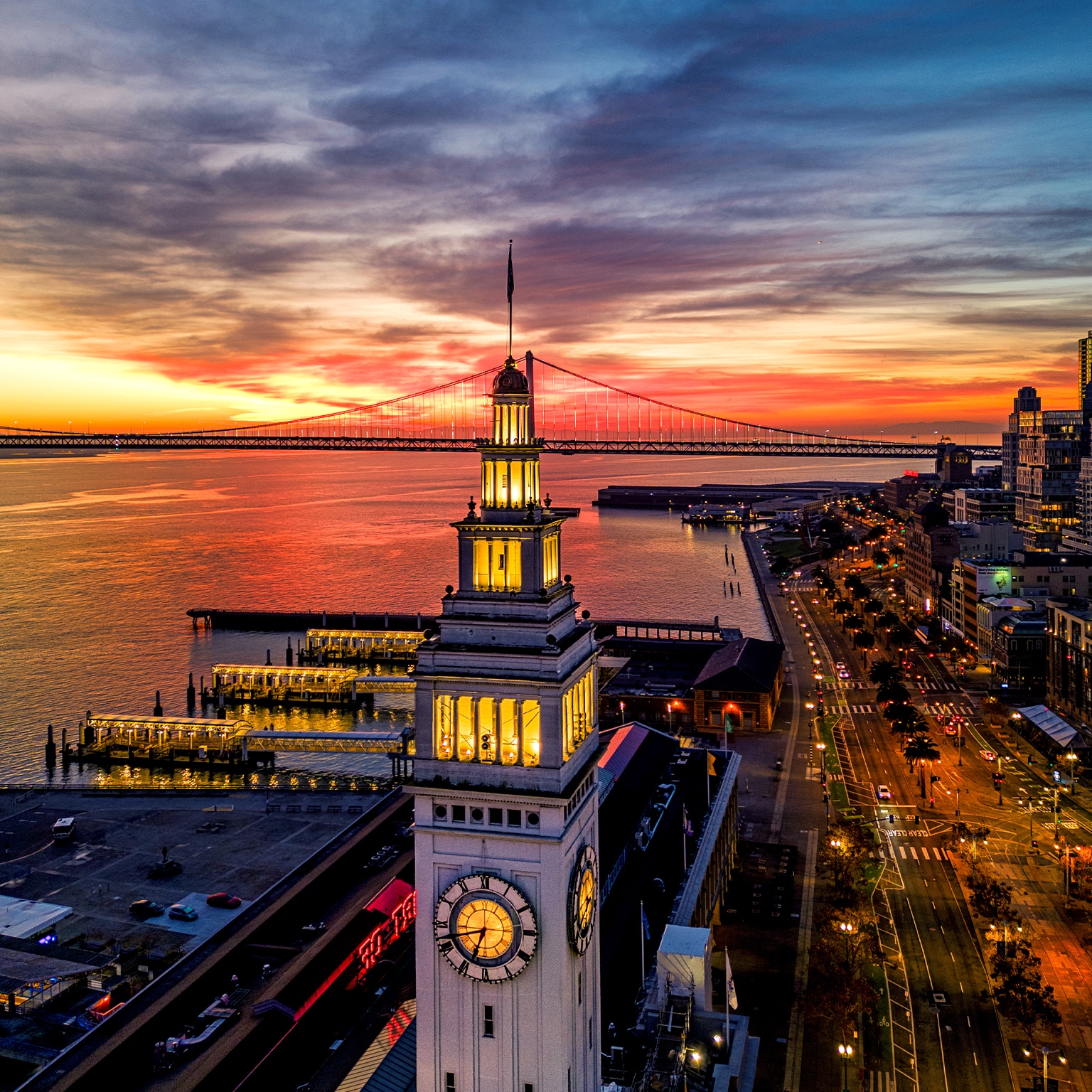 Aerial view of the Embarcadero with a burning sunrise and the Ferry Building