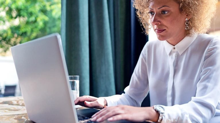 Freelancer working on her laptop at the restaurant - stock photo