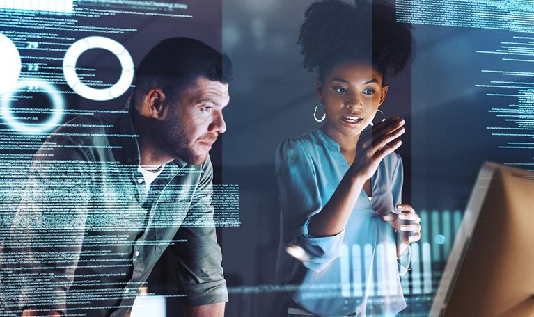 Shot of two programmers working together on a computer code at night - stock photo