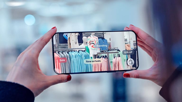 Female hand holding smartphone using augmented reality application to check special sale price in retail fashion store.