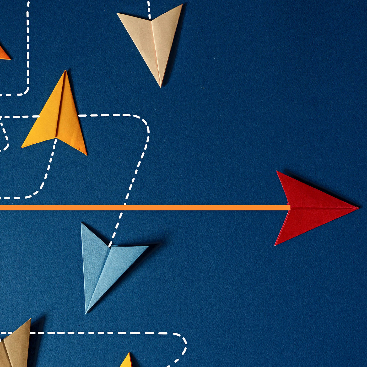 An image shows a group of multicolored paper planes tracing dotted lines in a swirling pattern, while a lone red paper plane rests at the end of a straight line.