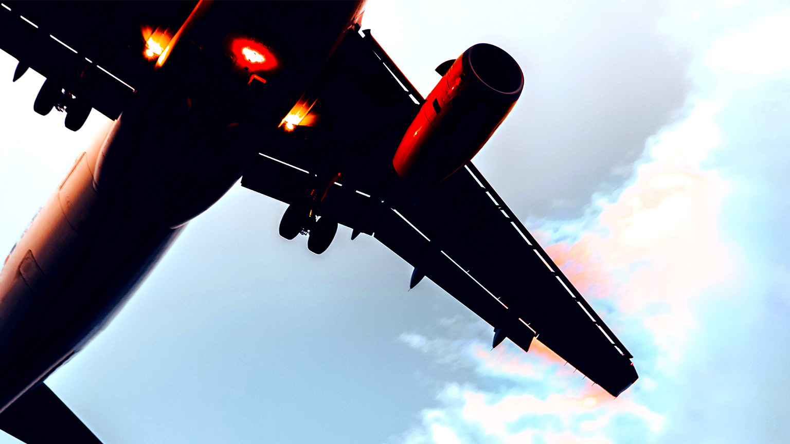Close up view from below of an airplane flying upwards