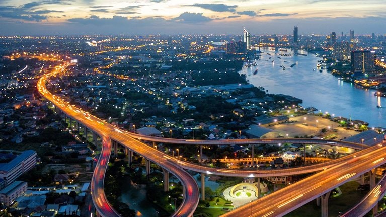 Aerial view of Bhumibol suspension bridge cross over Chao Phraya River in Bangkok city with car on the bridge at sunset sky and clouds in Bangkok Thailand. - stock photo