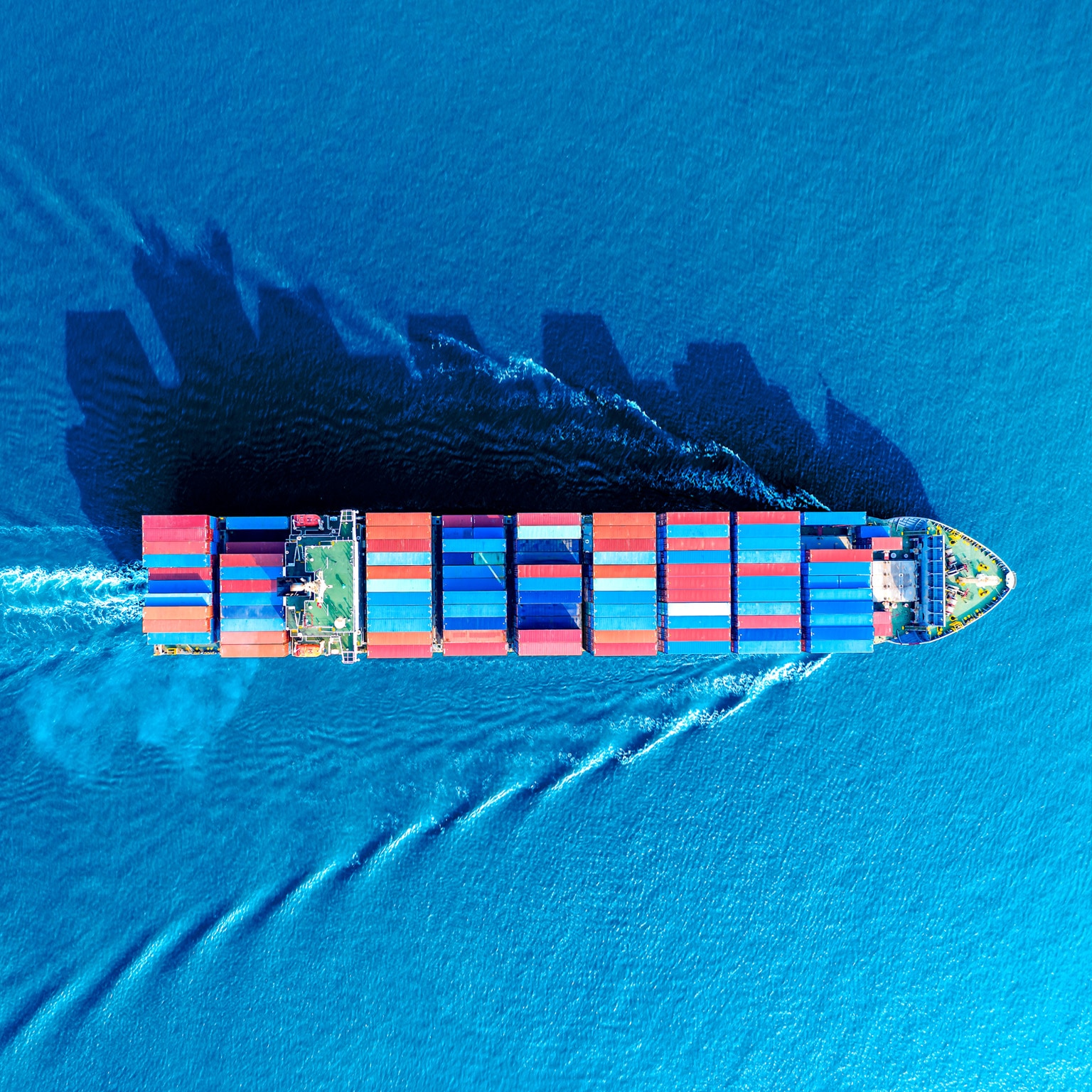 Aerial view of a container ship moving though the water