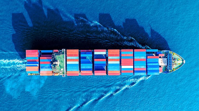 Aerial view of a container ship moving though the water