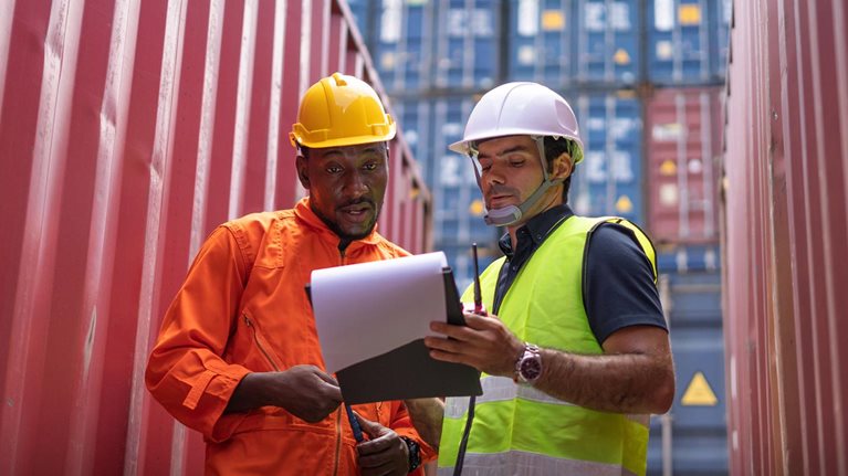 Logistic team checking stock at commercial dock yard. - stock photo