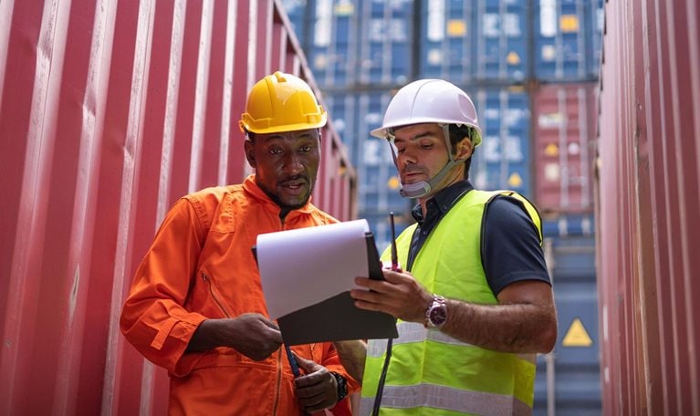 Logistic team checking stock at commercial dock yard. - stock photo