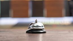 Hotel service bell on a table white glass and simulation hotel background. Concept hotel, travel, room - stock photo