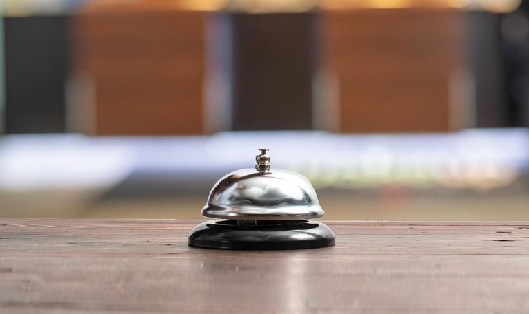 Hotel service bell on a table white glass and simulation hotel background. Concept hotel, travel, room - stock photo
