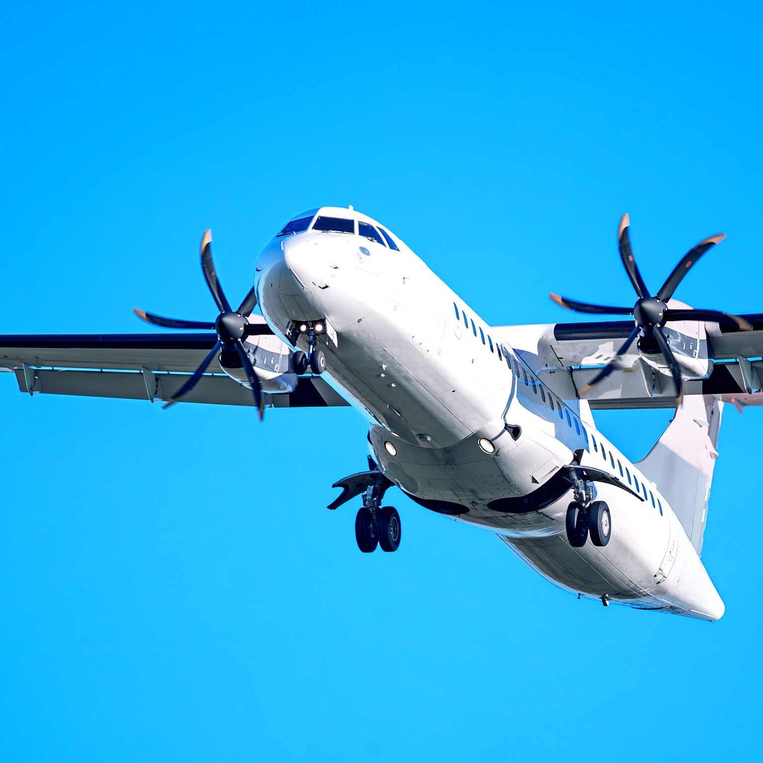 Image of an airplane taking off at night with blurred lit buildings in the background.