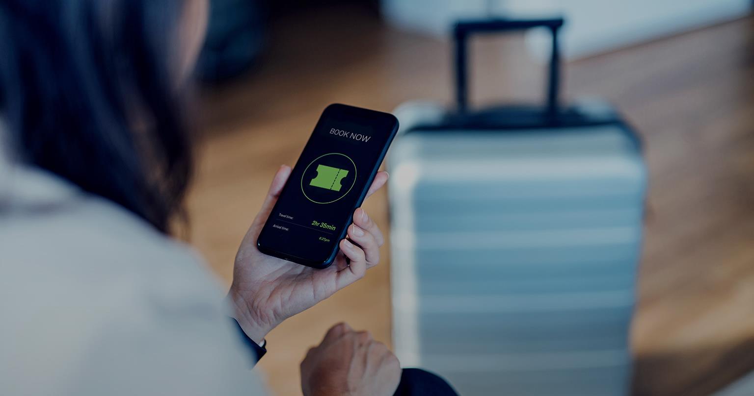 Close-up shot of a young businesswoman using mobile phone to arrange a ride in hotel room