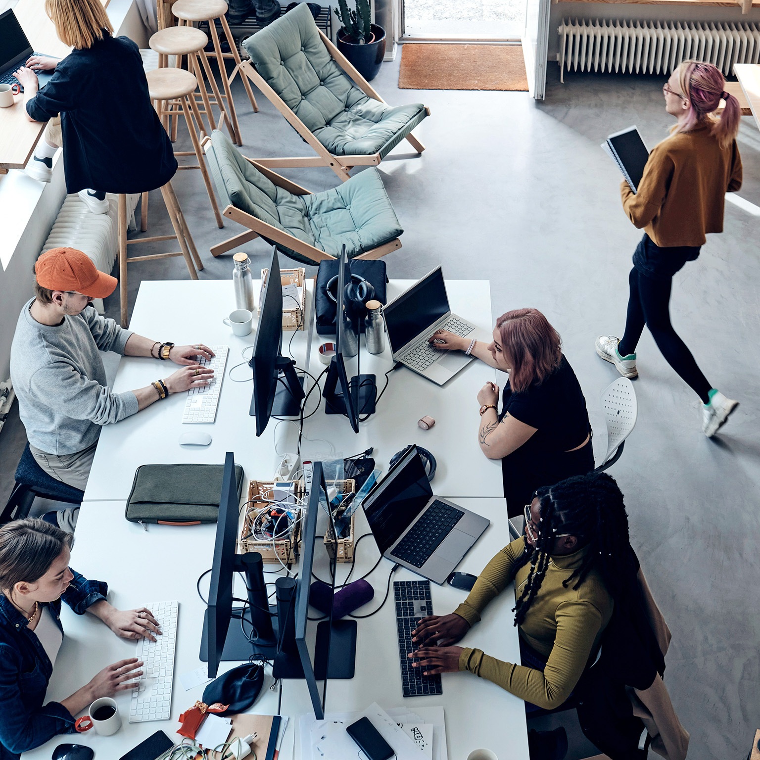 High angle view of male and female entrepreneurs working at tech start-up office