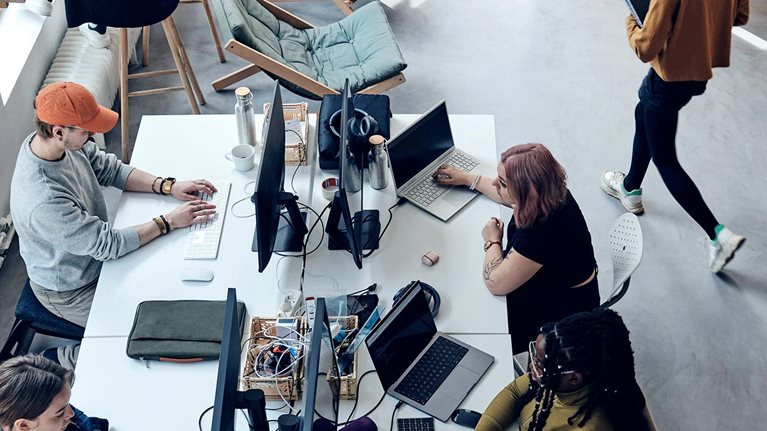 High angle view of male and female entrepreneurs working at tech start-up office