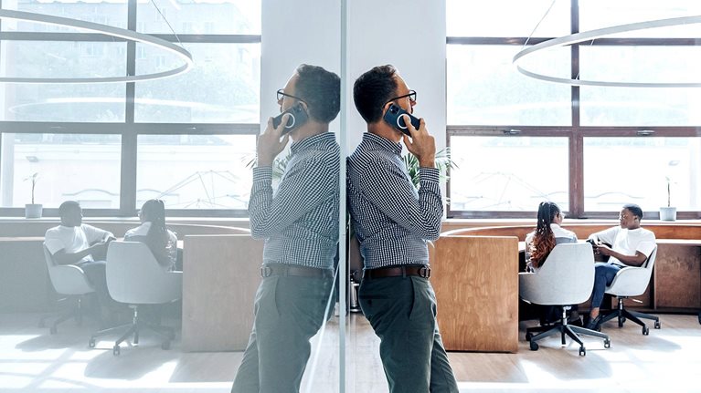 Businessman talking on phone in office.
