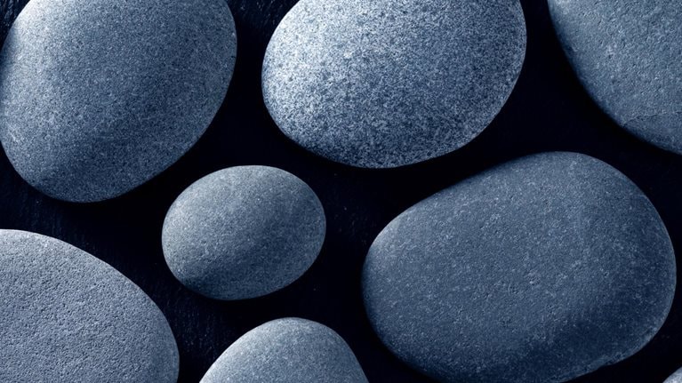 Smooth gray river stones on a black background.