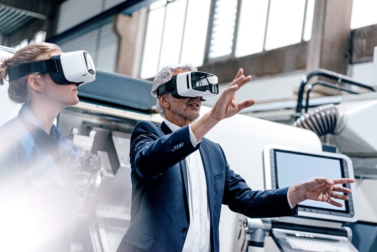Businessman and skilled worker in high tech enterprise, using VR glasses - stock photo