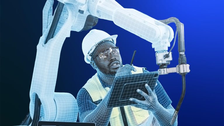A worker wearing a hard hat, safety glasses, and a high-visibility vest holds a tablet at a workstation, with a large industrial robotic arm rising behind him. Both the worker and the robotic arm are partly rendered in a translucent blue wireframe, blending the two together. A laptop on the desk displays engineering schematics, set against a gradient blue background.