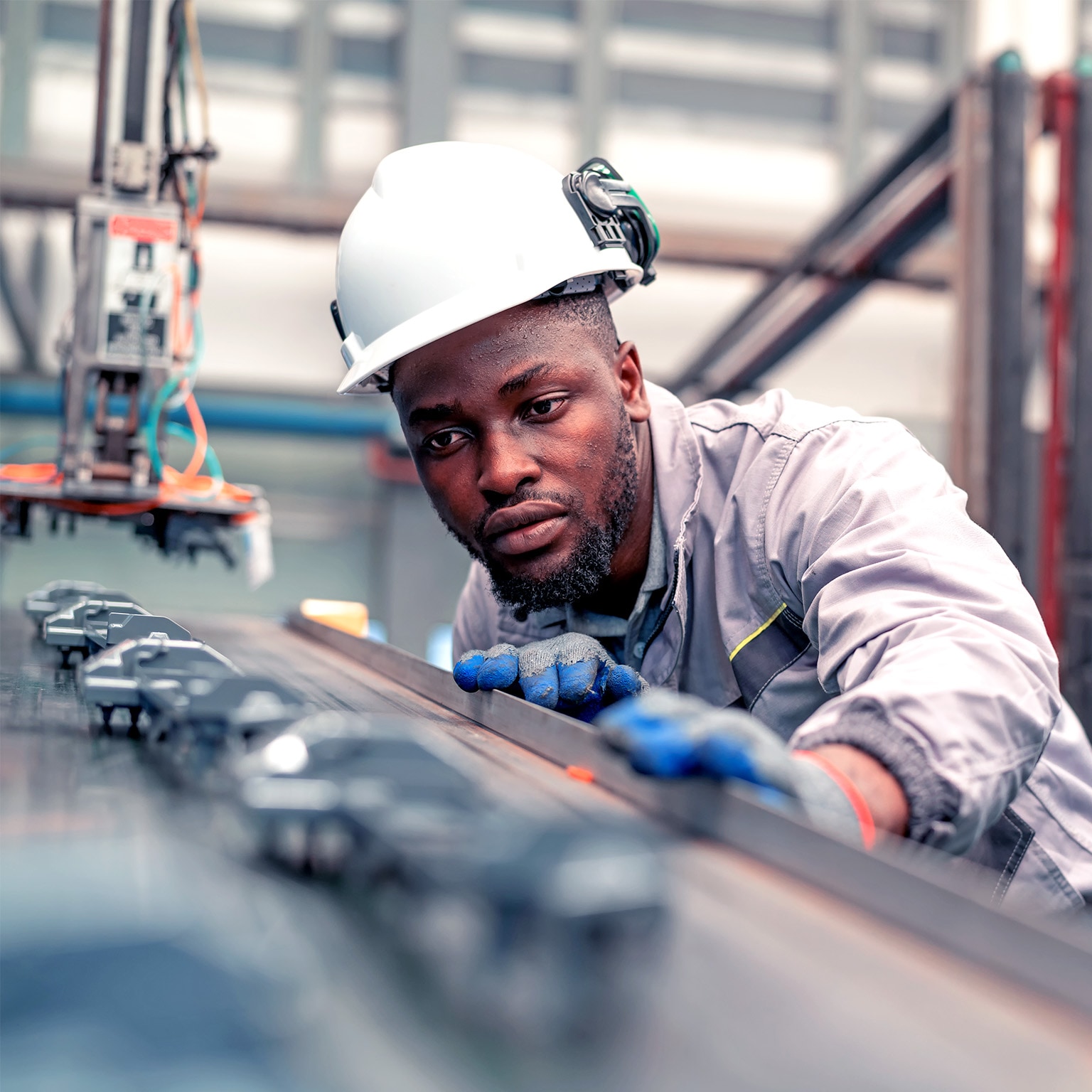 Quality engineer working in the automotive industry while checking the quality of components of automotive parts in the production line. 