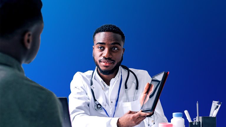Young African man having an African-American man doctor's appointment at medical clinic.