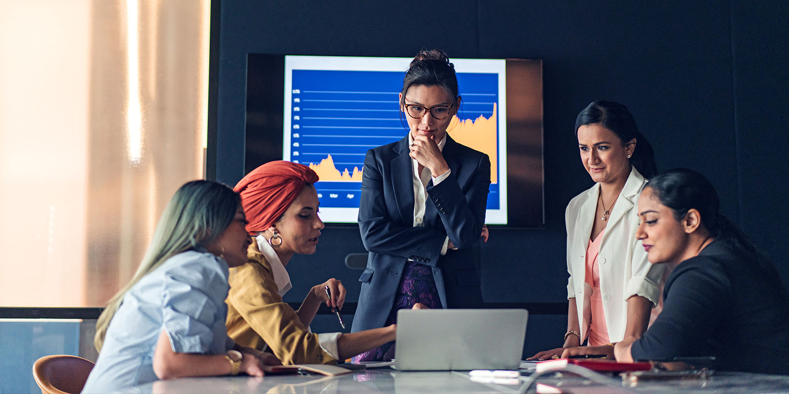 A confident female leader leading an all-female team meeting.