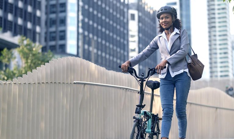 Image of a woman cycling to work in a city.