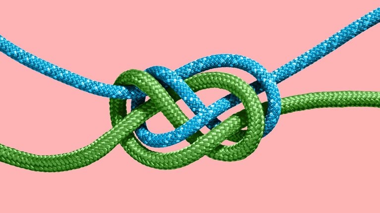 Two colored ropes knotted together.