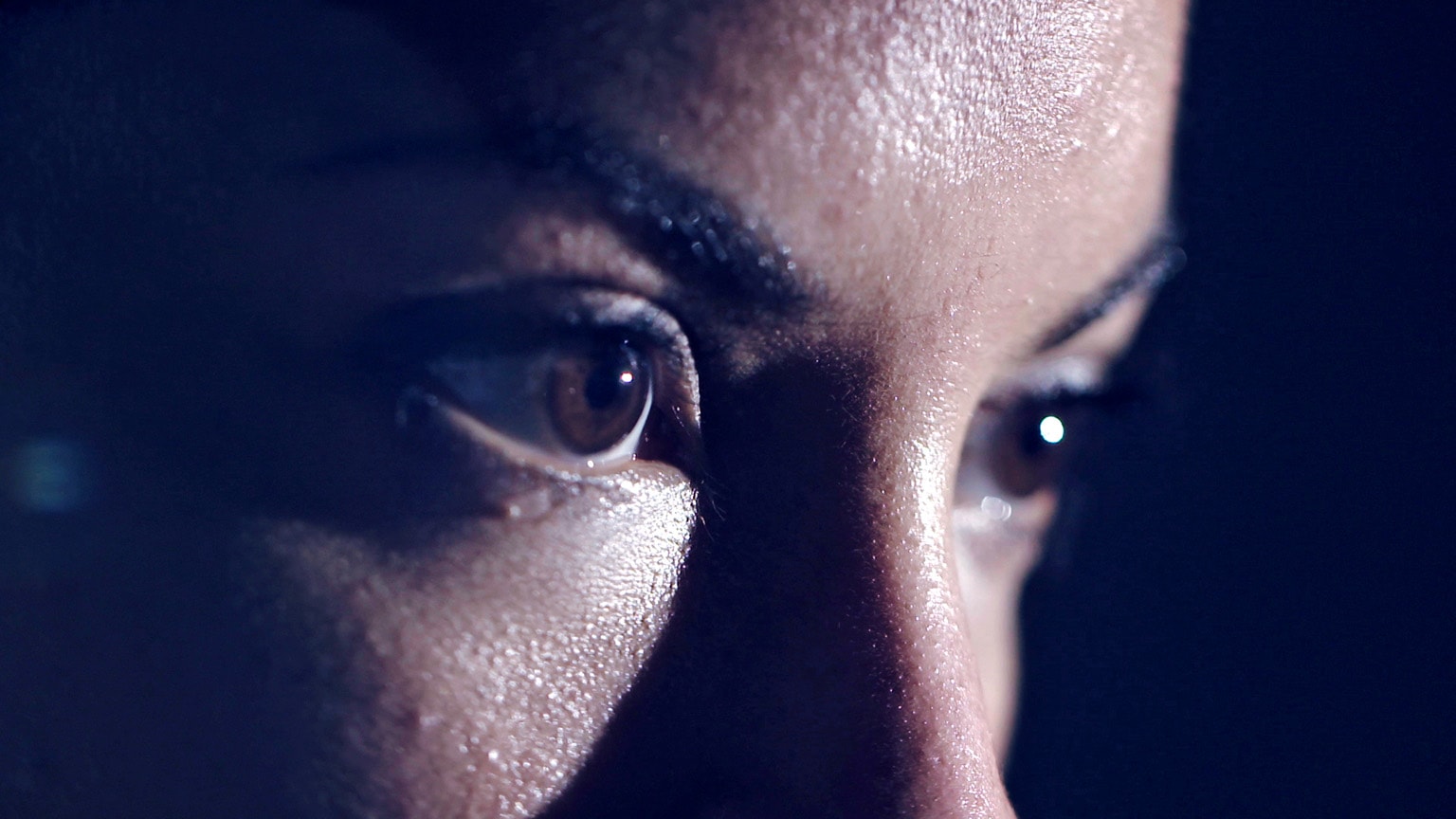 Close-up image of intensely focused eyes with some perspiration on the face.