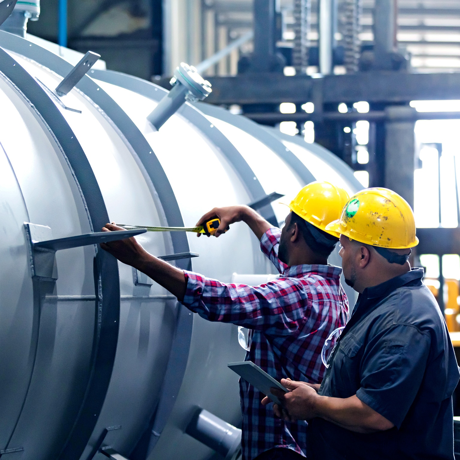 Two multiracial men working in metal fabrication plant