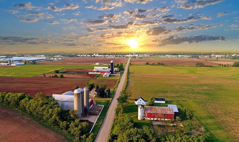 Idyllic rural agricultural landscape with dramatic sky at dawn