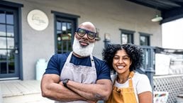 Portrait of father and daughter small business owners in front of family business