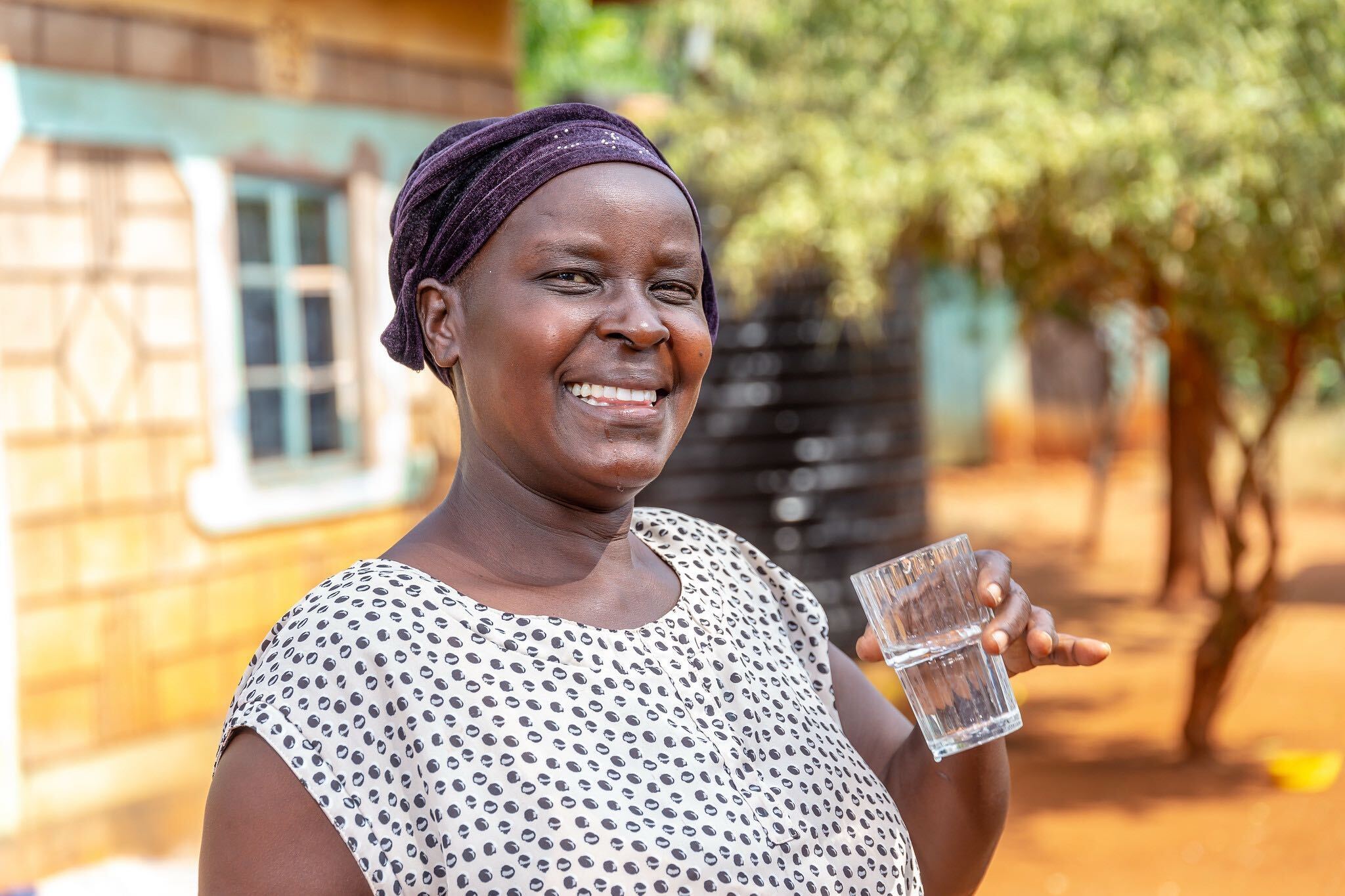 Woman smiling and holding a glass of water