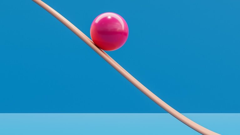 Computer generated image of pink sphere rolling down a plane like a roller coaster. - stock photo