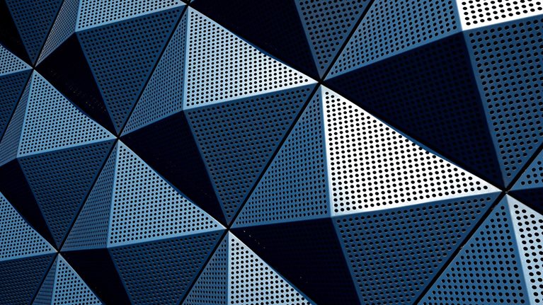 A wall composed of repeating metal triangular pyramids.